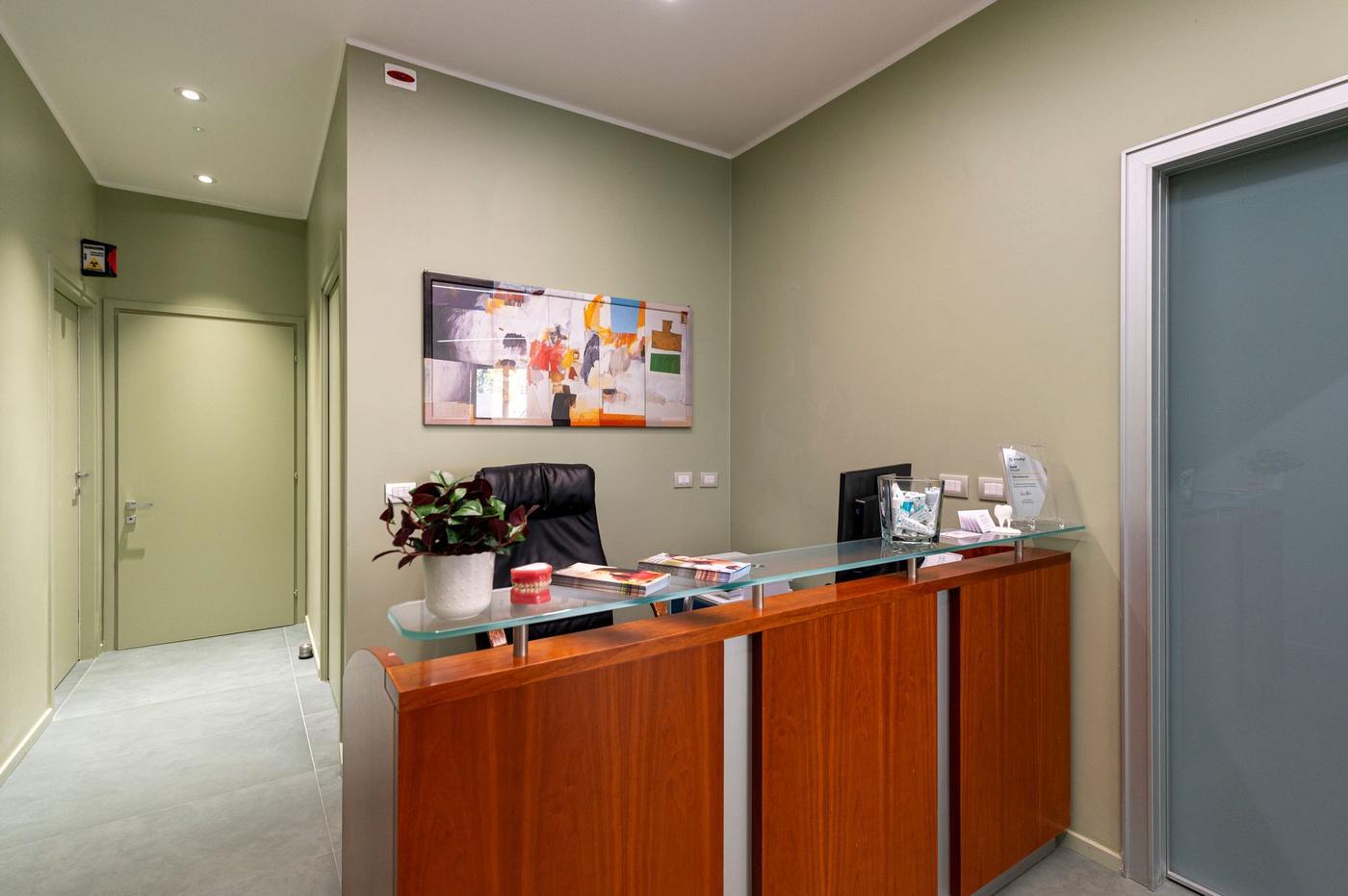 La reception dello studio, con il bancone in legno e vetro